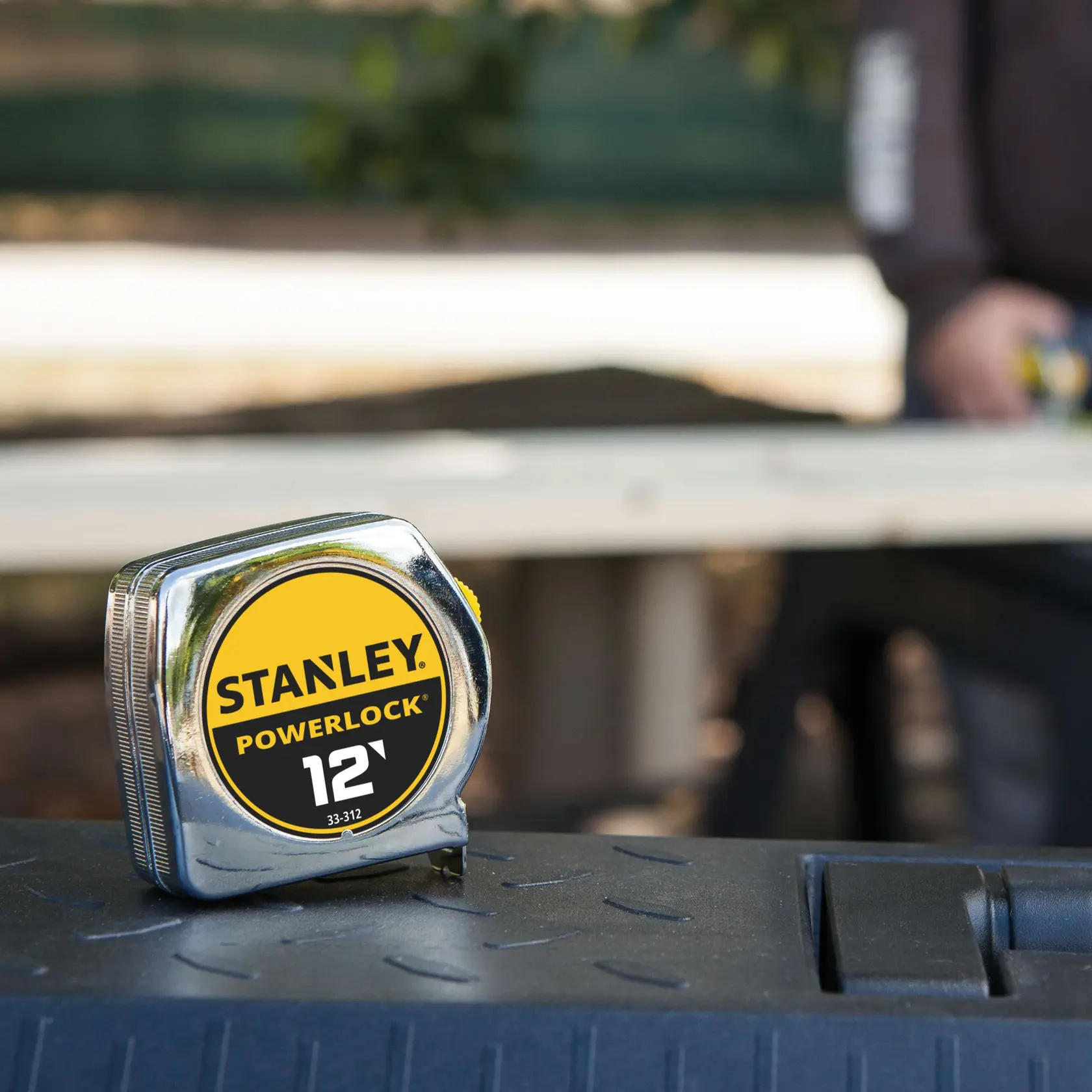 Fotografía del flexómetro Stanley PowerLock 12' 33-312 sobre una caja de herramientas al aire libre.