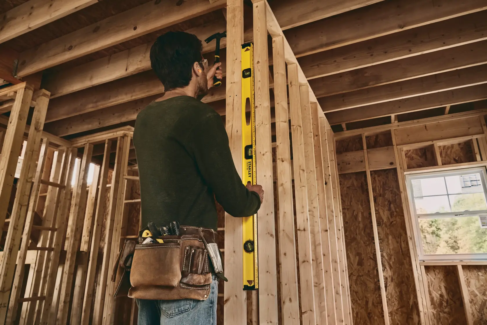 Fotografía de una persona usando el nivel de burbuja STANLEY 42-328 en una estructura de pared en obra.